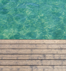 Fototapeta na wymiar Harbor board and deck path made of wood with turquoise sea background