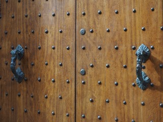 Ancient wooden door with decorated handles