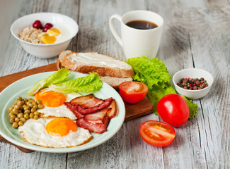 Breakfast with bacon and fried eggs, fruit and oatmeal. Morning coffee in a white cup. Menu for the cafe.