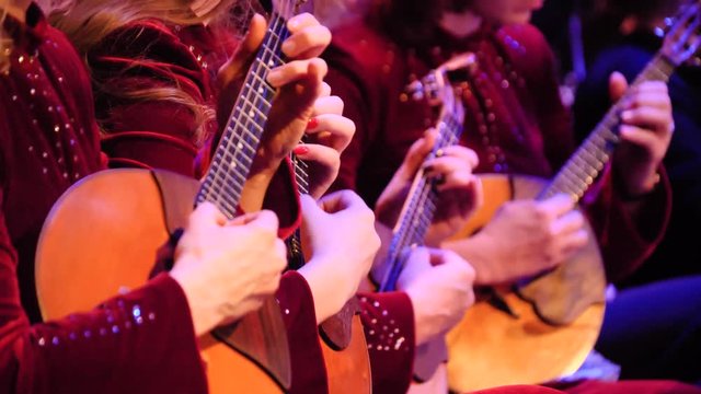 Women playing music with balalaika on concert. Russian instrument. Women play the balalaika
