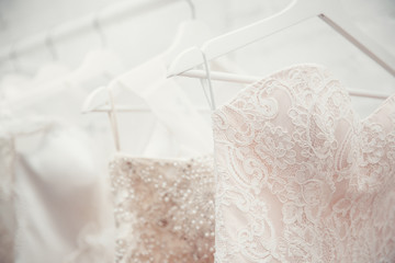 Copy space Wedding dresses for the bride on hangers against a white background of brick in the...