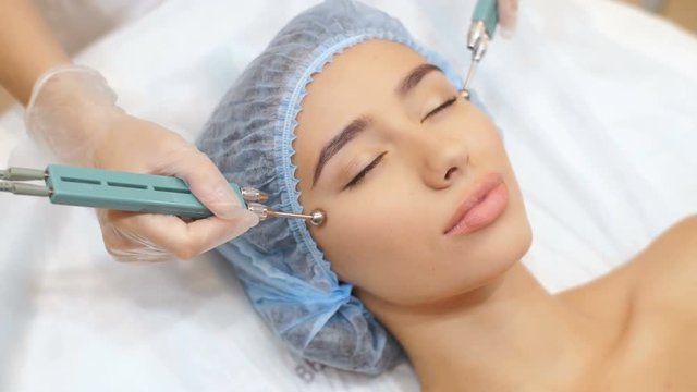 Woman having a stimulating facial treatment