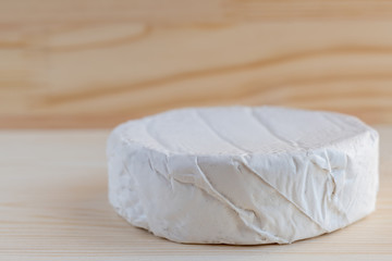 Fototapeta na wymiar Camembert or brie cheese on wooden background