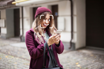 Face detection and unlocking of a mobile phone. A young girl is walking on the street. Face ID