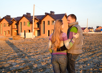 Rear view of young couple looking at their new house.