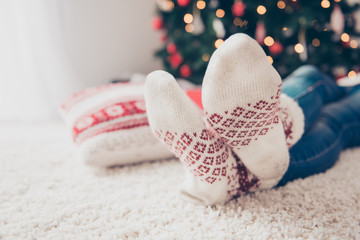 Close up low angle cropped shot of focus on pair of feet of festive lady, sitting down on floor on...
