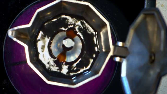 Moka pot brewing. Italian espresso coffee boiling in a moka pot close-up top view