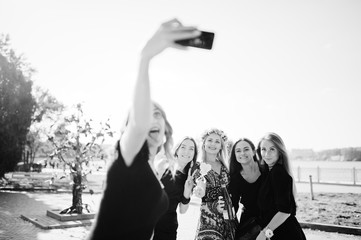Five girls wear on black having fun and making selfie at hen party.