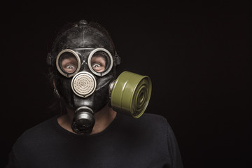 Portrait of man in gas mask with furious eyes, copy space