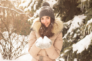 Young woman playing with snow