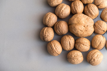 many walnut whole in shell on gray background