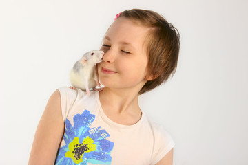 Shot of a happy little girl holding a Rat. Portrait of a little girl playing with her pet rat.   Portrait of a pretty young girl with her pet  rat.
