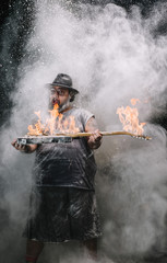 man with the guitar with fire between chalk and smoke dust