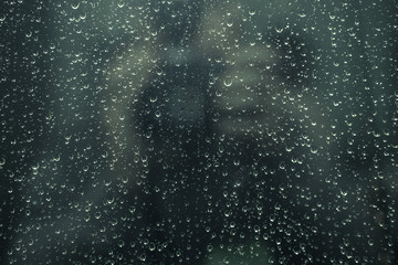 Naklejka na ściany i meble Rain drops on window glasses with cloudy background .