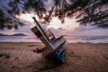 Wreck boat on beach with sunrise in Thailand.
