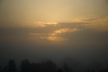 Summer sunrise landscape. Foggy background village.