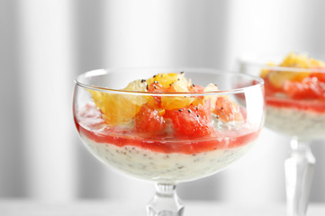 Glass with delicious chia seed pudding on blurred background, close up