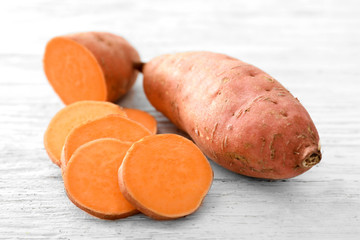 Raw sweet potato on wooden table