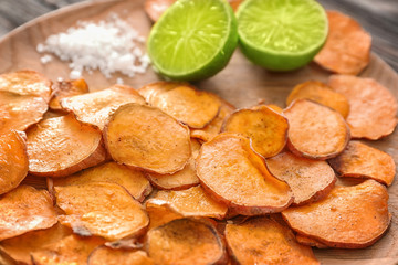 Plate with yummy sweet potato chips, closeup