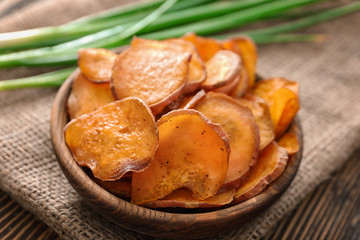 Bowl with yummy sweet potato chips on table