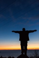 Fototapeta premium Man with Arms Open at Dawn / Sunset