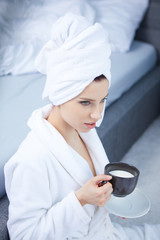 Beautiful woman enjoying morning coffee in bed