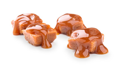 Sweet candies with caramel topping on white background