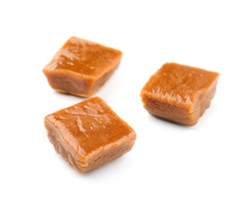 Sweet caramel candies on white background