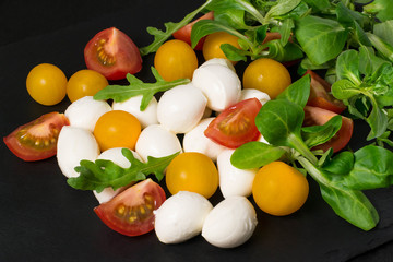 Mozzarella, tomatoes and different salad leaves