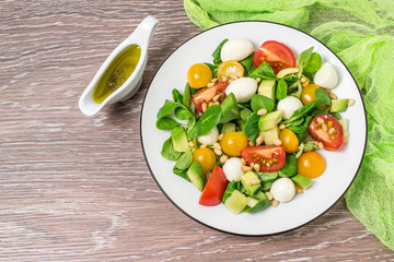 Fresh salad with mozzarella, tomatoes, avocado and lettuce