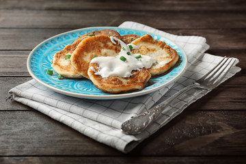 Plate with Hanukkah potato pancakes on table