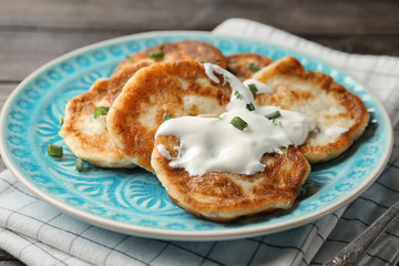 Plate with Hanukkah potato pancakes on table