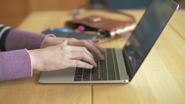 Dolly Shot Of Woman Typing On Laptop At Wooden Table