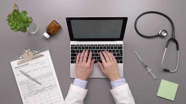 Overhead Top View Footage Of Doctor Typing On Laptop At Desk