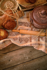 Different types of fresh bread, rolling pin and wheat spikes on old wooden table. Rustic concept. Top view. Copy space
