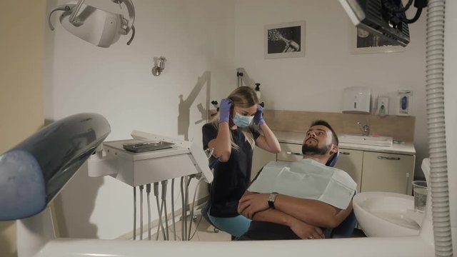 Female dentist wears mask during the dental surgery