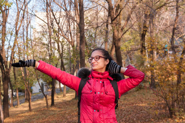 Happy teen girl in red jacket in the forest