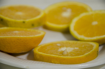 Naranjas en rodajas sobre un plato blanco. Fruta