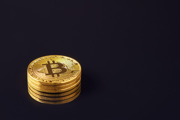 Gold bitcoin coin stacked against a dark background close-up. Bitcoin cryptocurrency