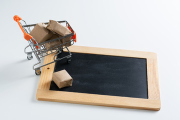 Small shopping cart and empty chalkboard