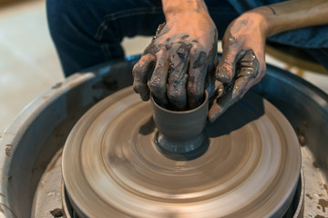 Craftsman hands working on the molding pottery clay old style.