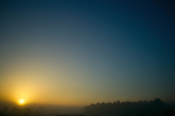 Summer sunrise landscape. Foggy background village.