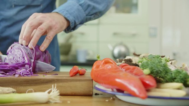 Vegetables In Plate By Man Cutting Red Cabbage At Kitchen