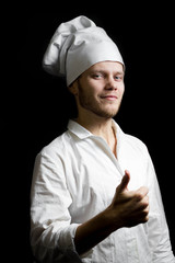 the chef shows her thumb up. Cook on a dark background