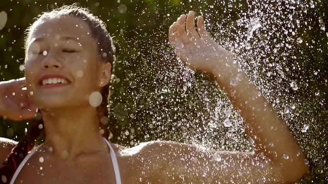 Close up shot of a beutiful girl taking cold shower.