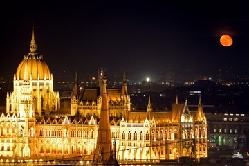 The parliament building at night with red moon, Budapest, Hungar