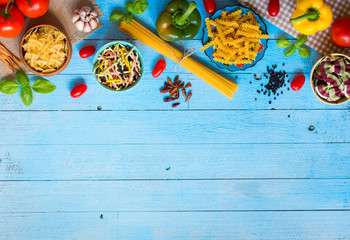 Fototapeta na wymiar Different types of pasta with various types of vegetables, health or vegetarian concept on a wooden background, Top view