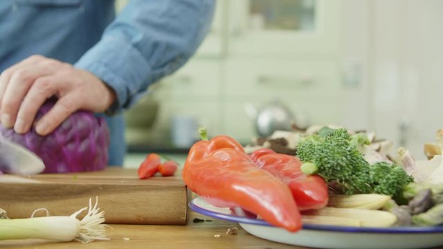 Vegetables In Plate By Man Cutting Red Cabbage At Kitchen