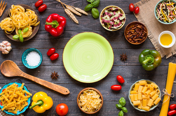 Different types of pasta with various types of vegetables, health or vegetarian concept on a wooden background,  Top view