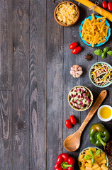 Different types of pasta with various types of vegetables, health or vegetarian concept on a wooden background,  Top view